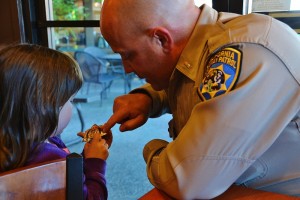 CHP Commander Lt. Daughrity reads badge inscriptions to Audrey Sternburg - photo by Gina Clugston