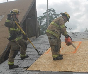 MCFD Engineer Adam Kernaghan (Station 3) (left) assists Firefighter Nick Sciaqua with roof ventilation demonstration - photo by Bill Ritchey