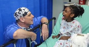 Image of a little girl sticking her tongue out for her doctor.