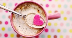 Image of a cup of hot chocolate with a pink candy heart on top.