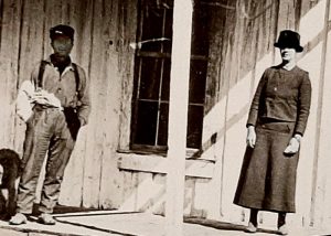 Nearly a century-old image of a couple on the porch of a cabin. 