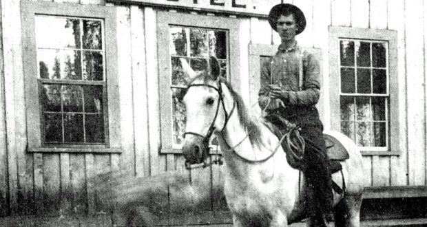 Antique image of cowboy on horseback in front of the Summerdale Hotel.