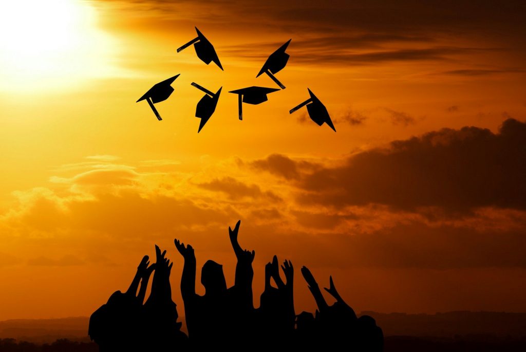 Image of graduates throwing their hats in the air.