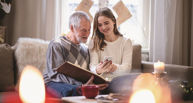 Image of a father and daughter reading a Christmas card.