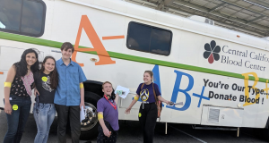 Image of students in front of a blood drive van.