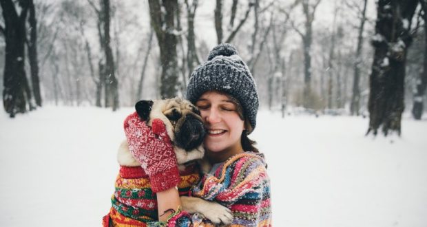 Image of a woman in the snow with her dog.