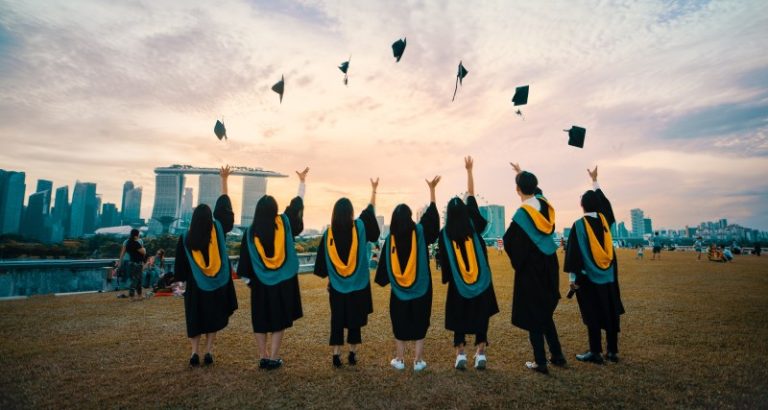 Image of students throwing their graduation caps in the air.
