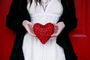 Image of a woman holding a Valentine's Day heart. 