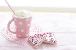 Image of a Valentine's Day cookie with a cup of coffee, all in pink.