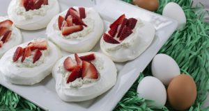 Image of meringue nests with strawberries and whipped cream.