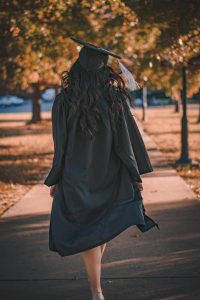 Image of a college graduate walking away from the camera. 