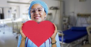 Image of a nurse holding up a paper heart.