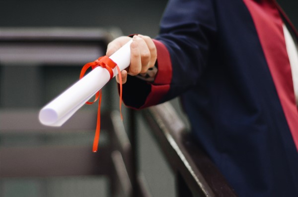Image of a hand holding a diploma.