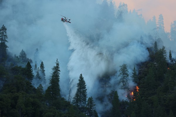 Image of a helicopter dropping water on a fire.