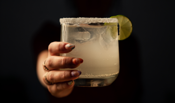 Image of a person offering a margarita. 