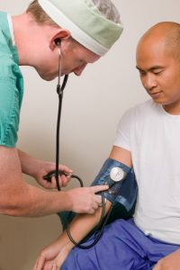 Image of a doctor checking a patient's blood pressure.