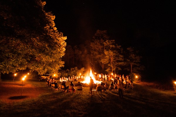 Image of a large group of people around a campfire. 