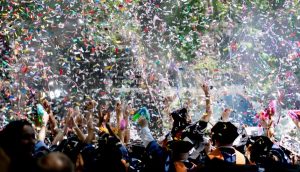 Image of a graduation ceremony with a massive amount of confetti in the air.