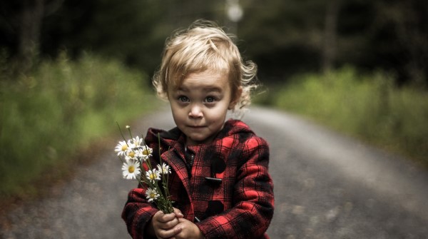 Image of a baby holding a flower. 