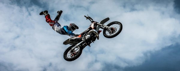 Image of a man flying through the air on a motorcycle. 