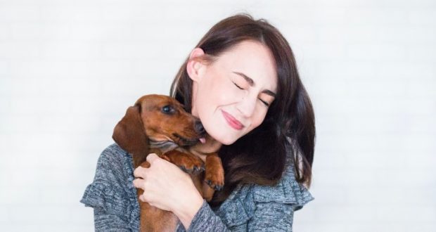 Image of a woman and a wiener dog.
