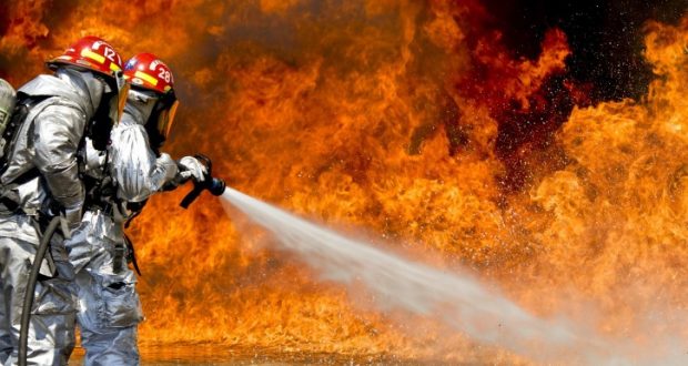 Image of two firefighters putting out a fire.