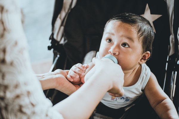 Image of a baby drinking from a bottle. 