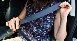 Image of someone fastening their seat belt.