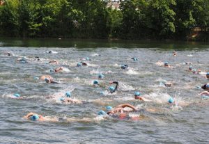 Image of people swimming in a lake during a triathlon. 