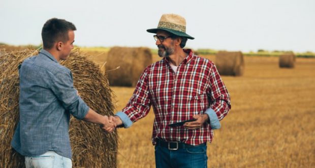 Image of a farmer shaking hands with another man.