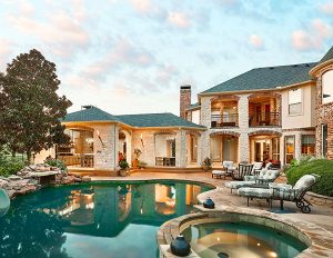 Image of the backyard of a large house with pool and jacuzzi. 