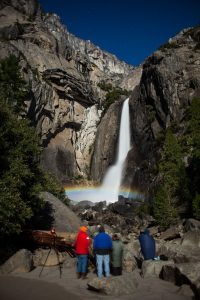 Image of a group of people watching a moonbow. 
