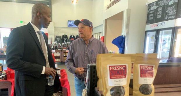 Image of Dr. St. Hilaire talking to another man inside the Fresno State bookstore.