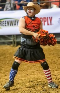 Image of a rodeo clown in a dress with pom poms. 