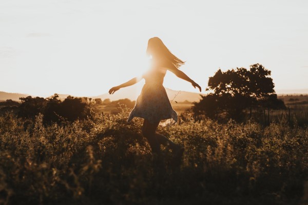 Image of a woman walking and being silhouetted by the sun. 