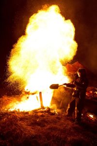 Image of a firefighter putting out a large fire. 