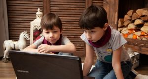 Image of two young boys looking at a computer screen.