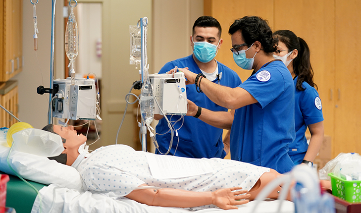 Image of nurses working on a practice dummy in a school hospital.