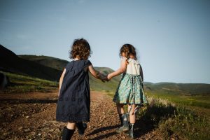 Image of two girls walking and holding hands.
