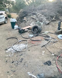 Image ID: a picture of the encampment. The stolen property is strewn about on the ground. End ID.