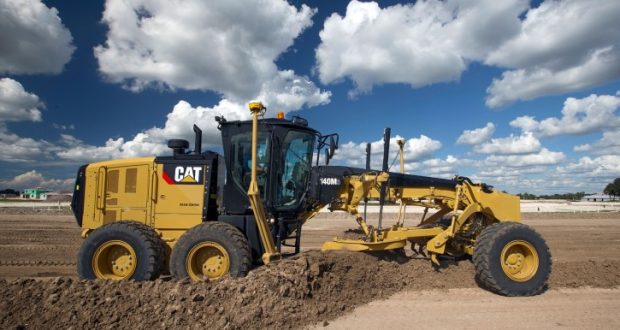 Image of a bulldozer/grader against a blue sky with clouds.