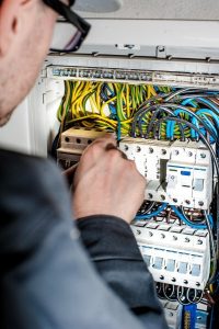 Image of an electrician working on an electrical panel.