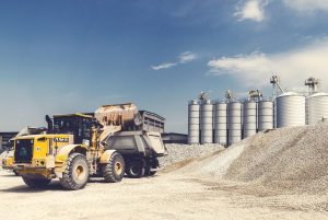 Image of a bulldozer in front of piles of gravel.