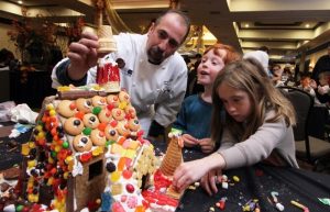 Image of people building a gingerbread house. 