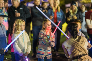 Image of children playing with light sabers. 
