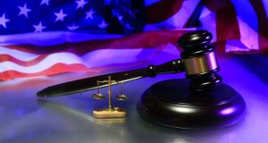 Image of a judge's gavel against a backdrop of an American flag.