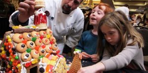Image of kids building a gingerbread house with a chef