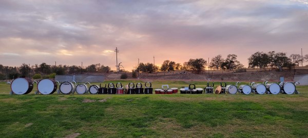 Image of a row of marching band equipment and drums. 
