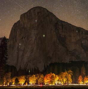 Image of El Capitan at night, with lights from climbers visible on its face.
