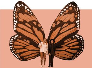 Image of two people standing in front of a giant butterfly mural.